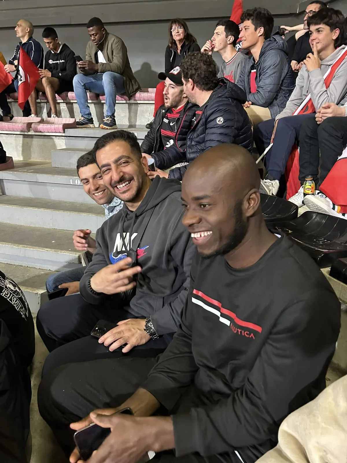 Deux bénéficiaires échangent en tribune lors d'une sortie de l'association